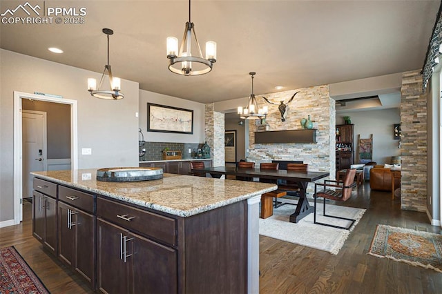 12857 Morning Breeze Way, Peyton, CO 80831 - kitchen featuring dark wood-style flooring, dark brown cabinetry, a chandelier, and open floor plan