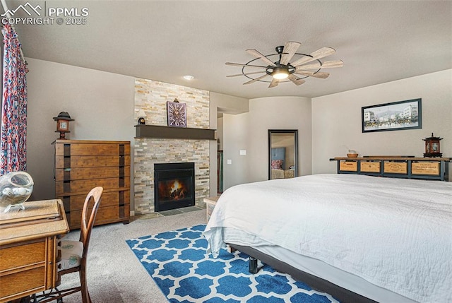 12857 Morning Breeze Way, Peyton, CO 80831 - bedroom featuring carpet, a ceiling fan, and a stone fireplace
