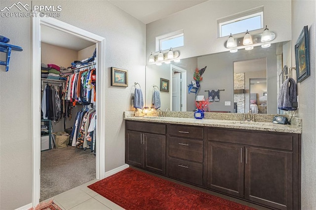 12857 Morning Breeze Way, Peyton, CO 80831 - full bath with connected bathroom, a walk in closet, a sink, tile patterned flooring, and double vanity