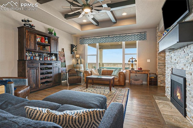 12857 Morning Breeze Way, Peyton, CO 80831 - living room with wood finished floors, a ceiling fan, a bar, and a fireplace