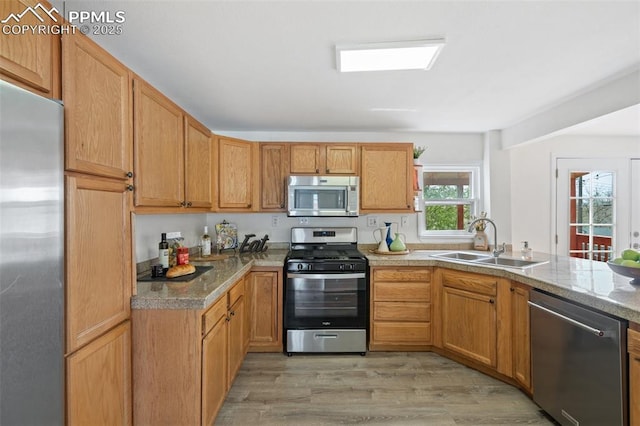 735 N Walnut St, Colorado Springs, CO 80905 - kitchen with stainless steel appliances, a sink, light wood finished floors, and a peninsula