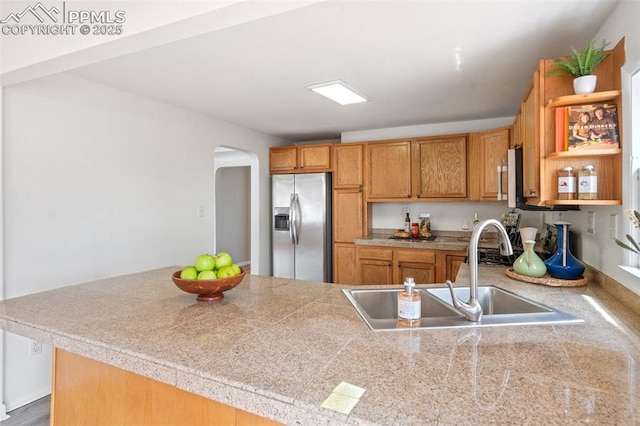 735 N Walnut St, Colorado Springs, CO 80905 - kitchen with open shelves, stainless steel fridge, a sink, tile counters, and arched walkways