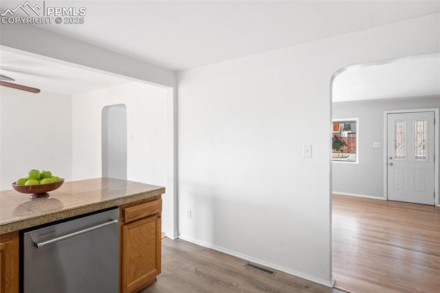 735 N Walnut St, Colorado Springs, CO 80905 - kitchen with tile countertops, visible vents, arched walkways, stainless steel dishwasher, and wood finished floors