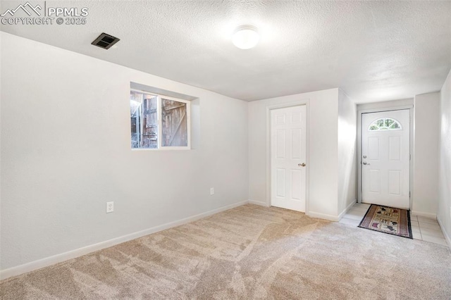 735 N Walnut St, Colorado Springs, CO 80905 - foyer entrance featuring carpet flooring, a textured ceiling, visible vents, and baseboards