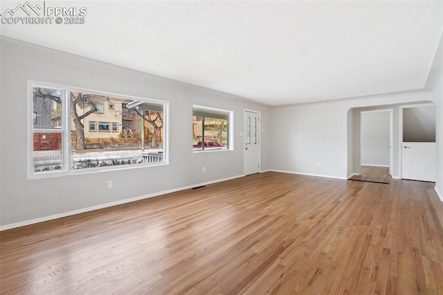 735 N Walnut St, Colorado Springs, CO 80905 - unfurnished living room with baseboards, a healthy amount of sunlight, and wood finished floors
