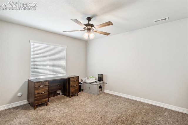 unfurnished office with baseboards, visible vents, light carpet, and a ceiling fan