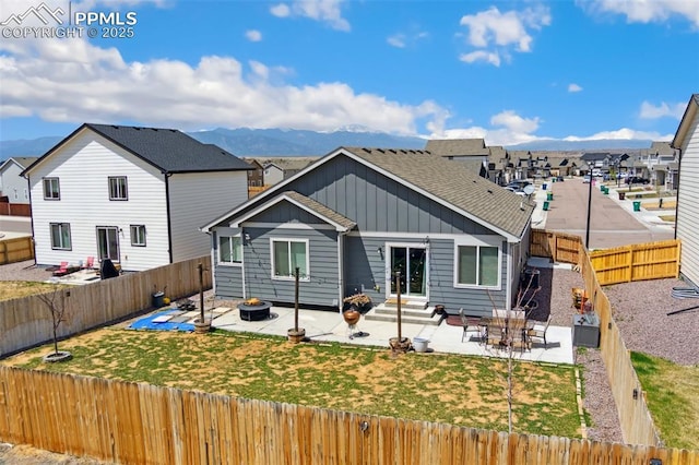 rear view of house with a patio, a fenced backyard, entry steps, and board and batten siding