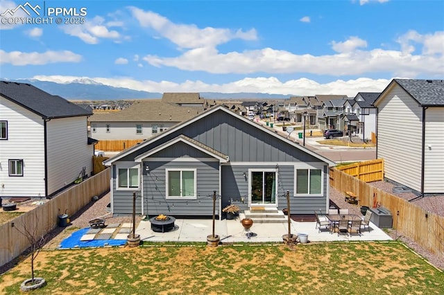 rear view of property with a lawn, board and batten siding, a patio, and a residential view