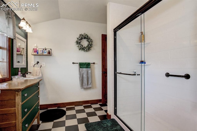 full bath with tile patterned floors, vanity, baseboards, a stall shower, and lofted ceiling