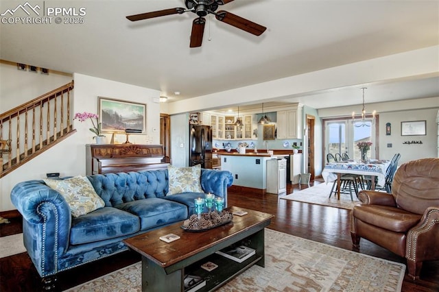 living room featuring wood finished floors, ceiling fan, and stairs