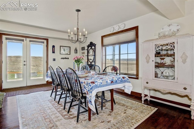 dining area featuring baseboards, wood finished floors, a notable chandelier, and french doors