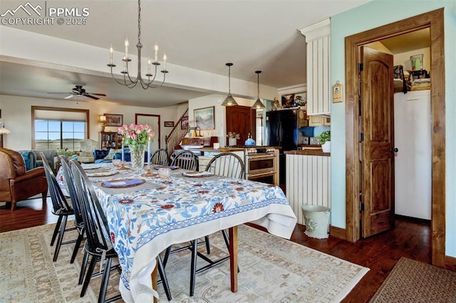 dining space featuring stairway, wood finished floors, and ceiling fan with notable chandelier