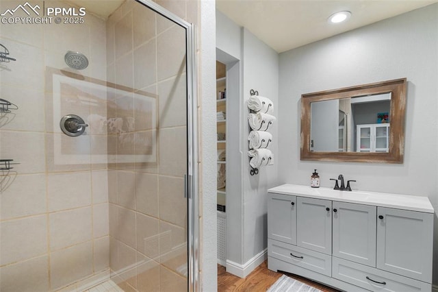 full bathroom with recessed lighting, vanity, wood finished floors, and a stall shower