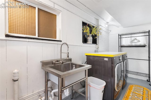 washroom with independent washer and dryer, a sink, and laundry area