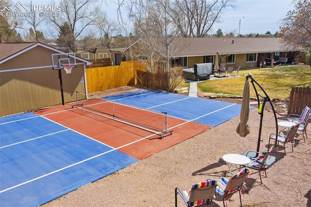 view of sport court featuring a lawn, fence, a tennis court, and basketball hoop