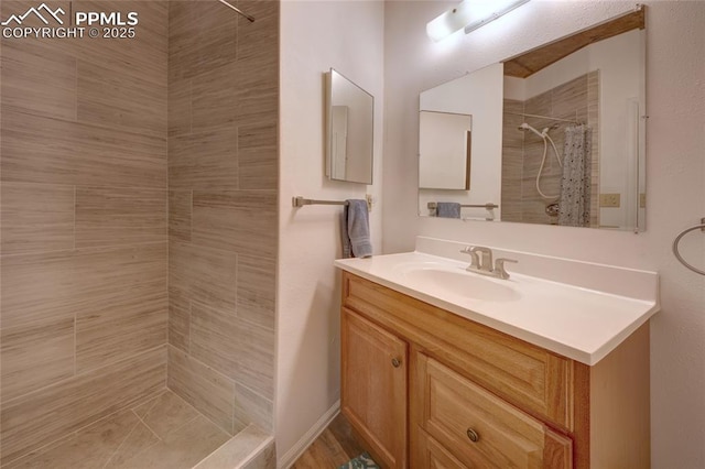 full bath featuring vanity and tiled shower