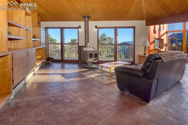 living room with wooden ceiling, a wealth of natural light, and a wood stove