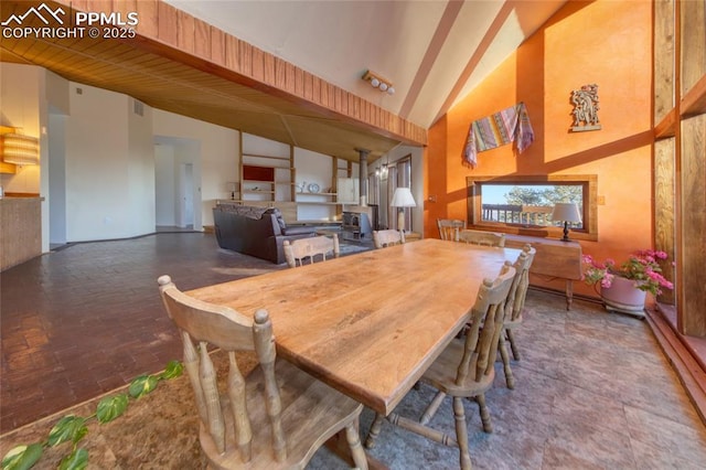 dining space featuring beam ceiling, high vaulted ceiling, and visible vents