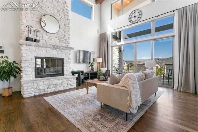 13625 Kitty Joe Ct, Colorado Springs, CO 80921 - living area with a fireplace, wood finished floors, a healthy amount of sunlight, and a towering ceiling