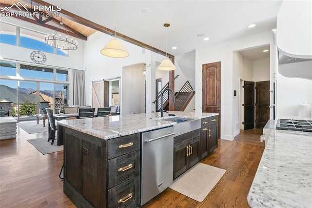 13625 Kitty Joe Ct, Colorado Springs, CO 80921 - kitchen featuring an island with sink, stainless steel dishwasher, a sink, beamed ceiling, and decorative light fixtures
