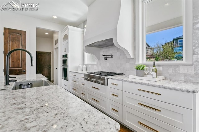 13625 Kitty Joe Ct, Colorado Springs, CO 80921 - kitchen with white cabinets, backsplash, appliances with stainless steel finishes, and a sink