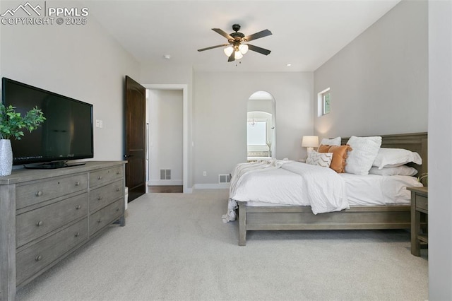 13625 Kitty Joe Ct, Colorado Springs, CO 80921 - bedroom with visible vents, light carpet, arched walkways, ensuite bath, and baseboards