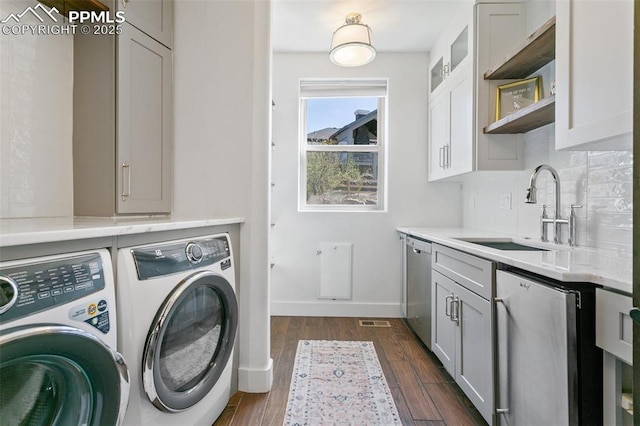 13625 Kitty Joe Ct, Colorado Springs, CO 80921 - laundry area with dark wood-style floors, washer and clothes dryer, a sink, visible vents, and baseboards