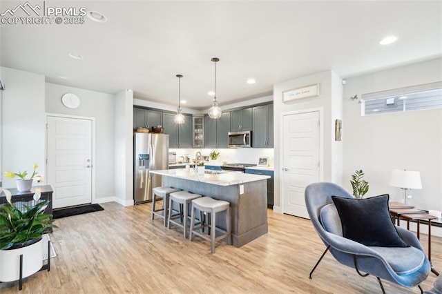 kitchen with light wood-style floors, a breakfast bar area, and stainless steel appliances