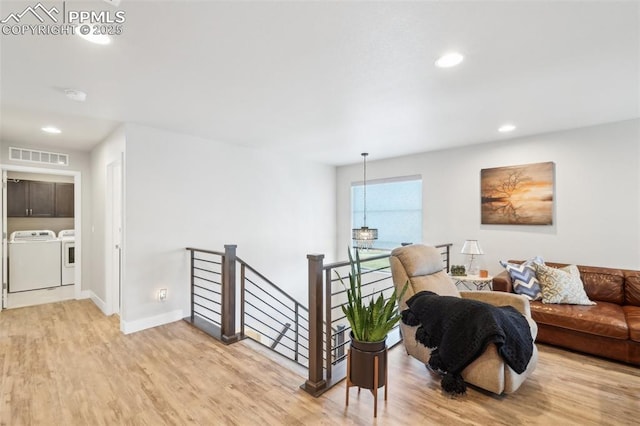 living area with recessed lighting, baseboards, light wood-type flooring, visible vents, and washing machine and dryer