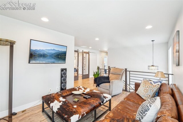 living room with recessed lighting, light wood finished floors, and baseboards