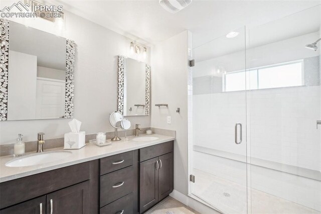full bathroom featuring double vanity, a sink, and a shower stall