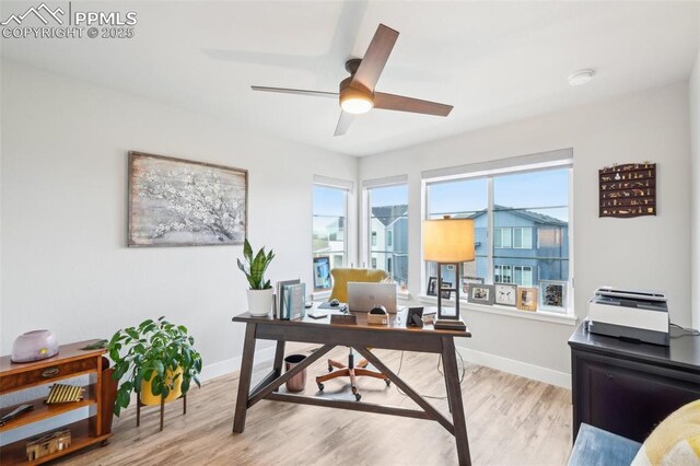 office area featuring baseboards, light wood finished floors, and ceiling fan