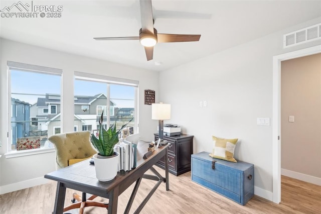 home office featuring visible vents, a ceiling fan, baseboards, and light wood-style floors