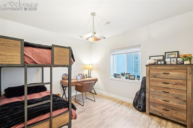 bedroom featuring baseboards, light wood finished floors, and visible vents