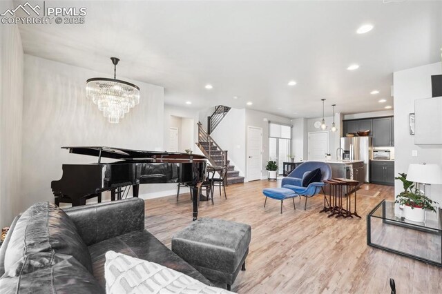 living room featuring light wood-style floors, recessed lighting, stairs, and a chandelier