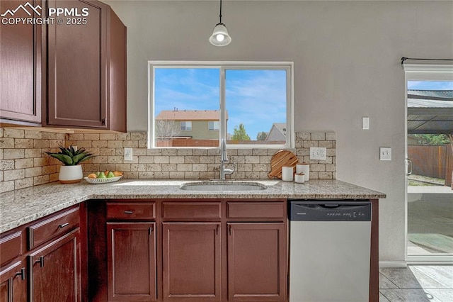 kitchen featuring a healthy amount of sunlight, decorative backsplash, pendant lighting, stainless steel dishwasher, and a sink