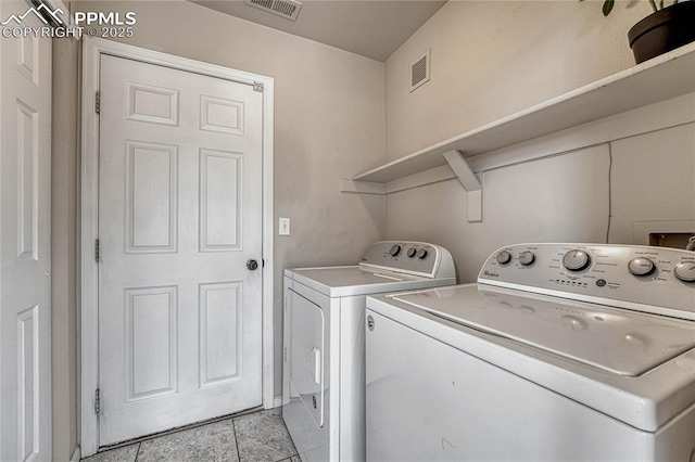laundry area featuring washer and dryer, light tile patterned flooring, laundry area, and visible vents