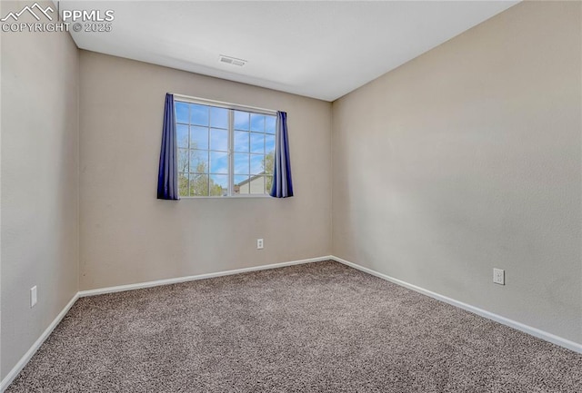spare room featuring carpet floors, baseboards, and visible vents
