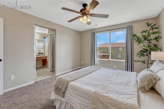 carpeted bedroom with baseboards, a ceiling fan, and ensuite bath