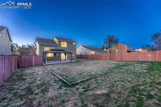 back of property featuring a fenced backyard, a patio, and a gazebo