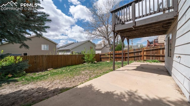 fenced backyard with a patio area and a wooden deck