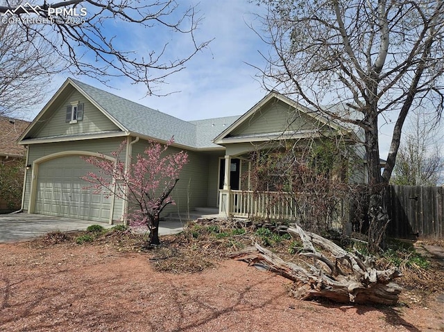 ranch-style house with roof with shingles, a porch, concrete driveway, fence, and an attached garage