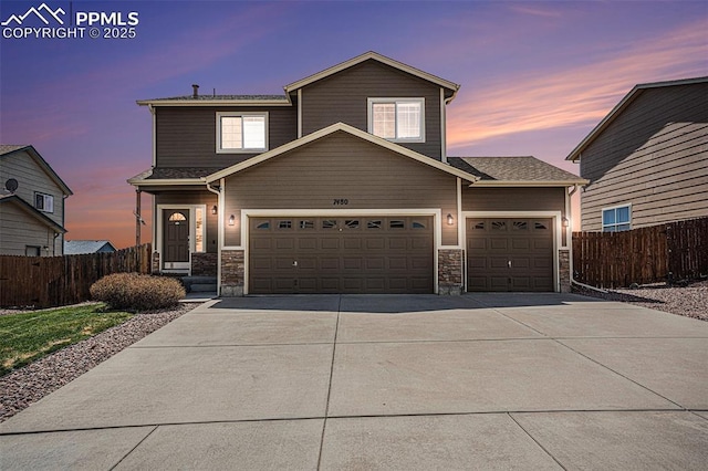 7480 Twin Valley Ter, Colorado Springs, CO 80925 - view of front of home featuring driveway, stone siding, a garage, and fence