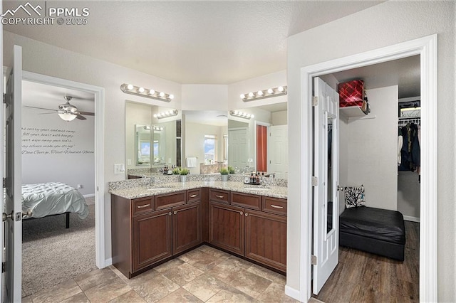 7480 Twin Valley Ter, Colorado Springs, CO 80925 - bathroom with a sink, double vanity, ceiling fan, a spacious closet, and ensuite bath