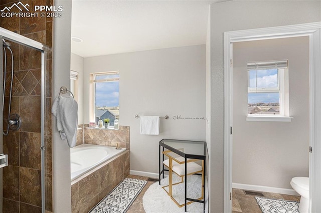 7480 Twin Valley Ter, Colorado Springs, CO 80925 - bathroom with baseboards, a stall shower, a bath, and plenty of natural light