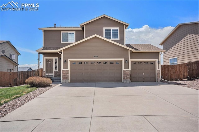7480 Twin Valley Ter, Colorado Springs, CO 80925 - view of front of house featuring fence, driveway, an attached garage, and stone siding