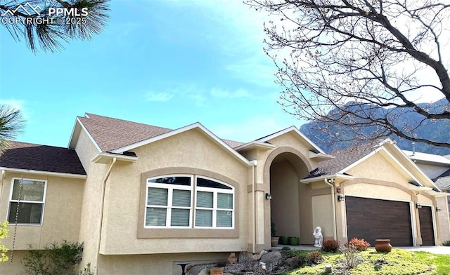 65 Kirkstone Ln, Colorado Springs, CO 80906 - view of front of house featuring stucco siding, a garage, driveway, and a shingled roof