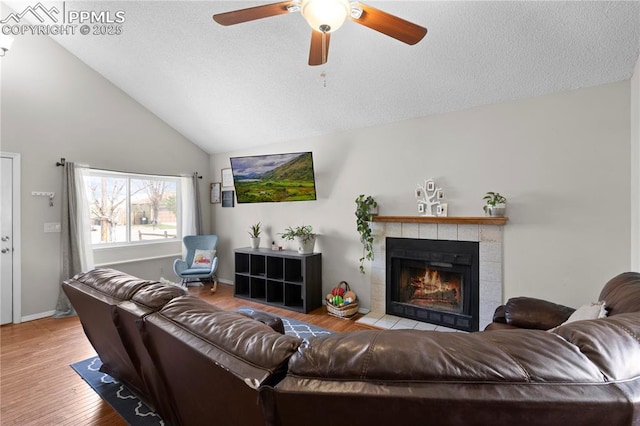 537 Blossom Field Rd, Fountain, CO 80817 - living room featuring high vaulted ceiling, a ceiling fan, wood finished floors, a textured ceiling, and a tiled fireplace