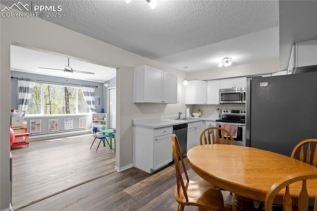 537 Blossom Field Rd, Fountain, CO 80817 - kitchen featuring a textured ceiling, light countertops, appliances with stainless steel finishes, white cabinetry, and dark wood-style flooring