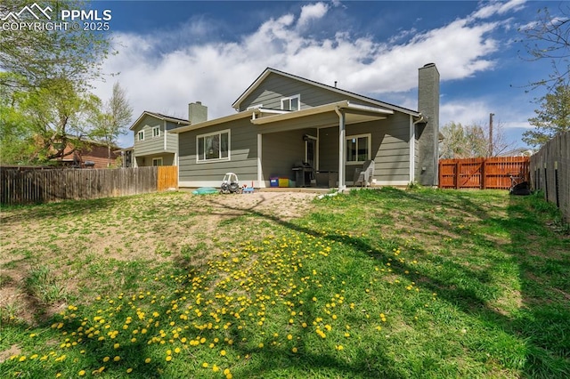 537 Blossom Field Rd, Fountain, CO 80817 - back of house with a chimney, a yard, a patio area, and a fenced backyard